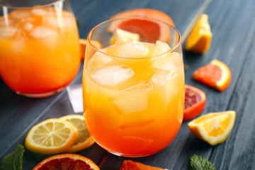 Glass of delicious tequila sunrise cocktail on wooden background