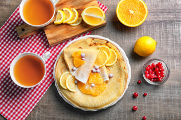 Delicious pancakes with orange and  cranberry on plate