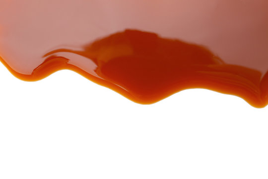 Tasty caramel sauce on white background, closeup