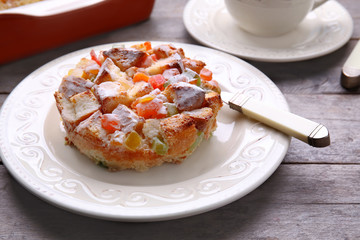 Delicious bread pudding with candied fruits on table