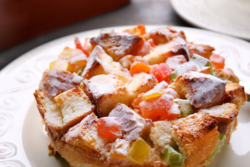 Delicious bread pudding with candied fruits on table