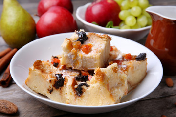Delicious bread pudding with fruits on table