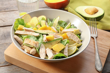 Plate with chicken salad on table