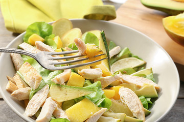 Plate with chicken salad on table