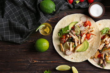 Delicious taco with tequila lime chicken on wooden background