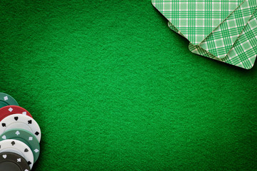 Cards and chips on green felt casino table. Abstract background with copy space.