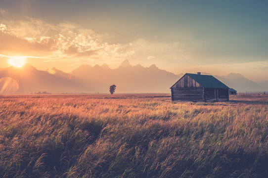Old farmhouse on grassy landscape in Grand Teton National Park