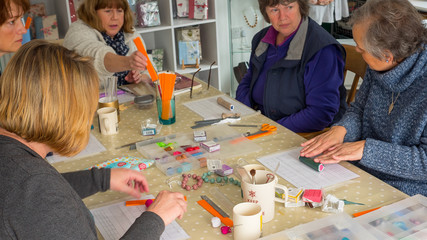 Group of women in art class learning how to make polymer clay jewellery
