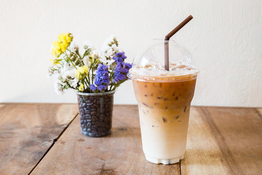 Glass of ice latte coffee on wooden table ready to drink