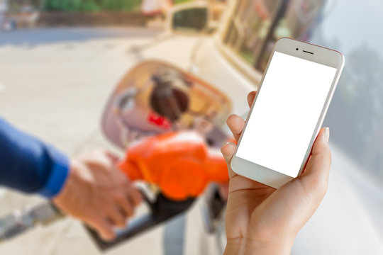 Women use mobile phone ,  image of car refueling on petrol station and fuel pump with gasoline  in the background.