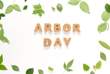 Arbor Day text with green leaves top view