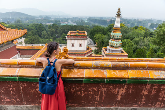 Young Girl Backpacker Relaxing Enjoying Travelling Looking At Nature View From Old Chinese Temple, Tourist Attraction In Beijing, China. Summer Palace Tourism Destination, Asia Travel.