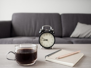 A cup of coffee on wood table . Simple breakfast or coffee break in morning/ selective focus.Blank seating  indoor in living room .copy space for create idea.