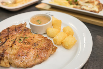 Pork steak with pepper sauce served with hash brown potato on white plate