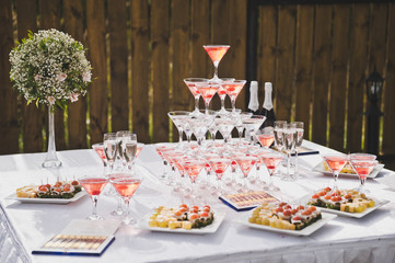 Beautiful holiday table with snacks and a pyramid of glasses 7726.