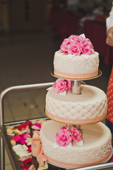 A three tiered cake with pink flowers 7827.