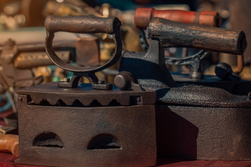 macro old coal iron on counter in sunday flea market. Antique bazaar