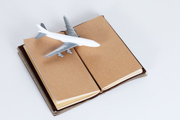 open blank notebook and toy plane, travel concept