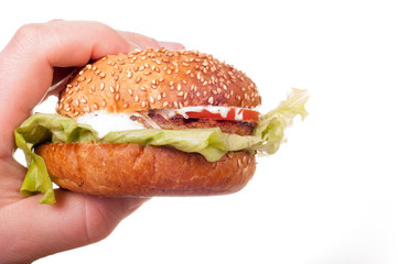 Hand holds fresh hamburger. Isolated on a white background
