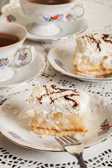 Fresh sweet apple cake with whipped cream served with cup of tea
