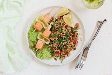 Tabbouleh and salmon skewerws.Traditional bulgur salad with vegetables and herbs. Selective focus 