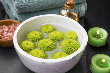 Spa floral water bowl, beauty treatments water, spa setting with burning candles, wellness therapy