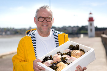 Portrait of a senior fisherman with scallop he just  collect