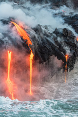Fototapeta na wymiar Molten lava flowing into the Pacific Ocean on Big Island of Hawaii at sunrise
