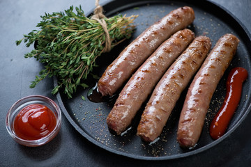 Close-up of a frying pan with roasted marbled beef sausages, horizontal shot, shallow depth of field