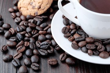 Coffee cup and coffee beans on wooden background