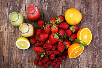 several bottles with fruit and berry juices smoothies and milkshakes , vintage wooden background, selective focus