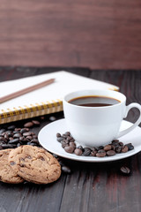 Coffee cup and coffee beans on wooden background