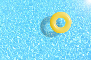 Fototapeta na wymiar yellow swimming pool ring float in blue water. concept color summer.