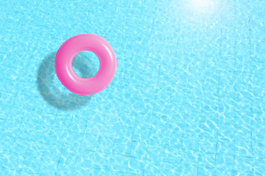 Fototapeta pink swimming pool ring float in blue water. concept color summer.