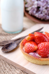Tart with fresh strawberry on wooden background,