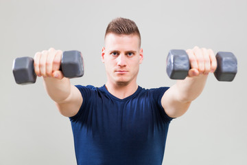 Studio shot image of young man who is exercising with weights. 