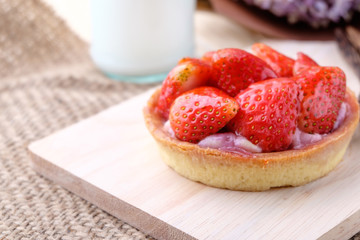 Tart with fresh strawberry on wooden background,