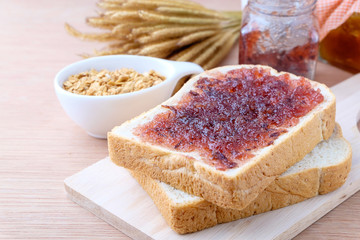 Bread with jam grape on wood background