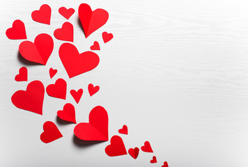 Wooden white background with red hearts. The concept of Valentin