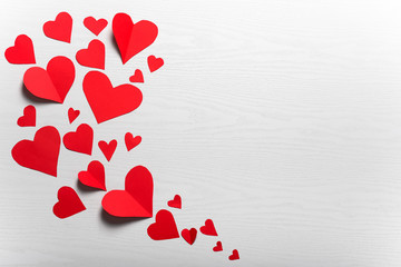 Wooden white background with red hearts. The concept of Valentin