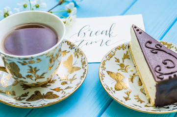 Still life with cup of tea and cake on the wooden background