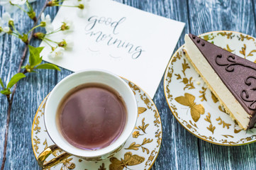 Still life with cup of tea and cake on the wooden background