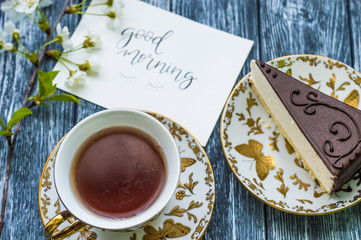 Still life with cup of tea and cake on the wooden background