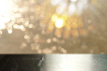 top of black wood table with gold silver bokeh light background