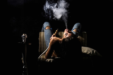 Woman in jeans smoking hookah
