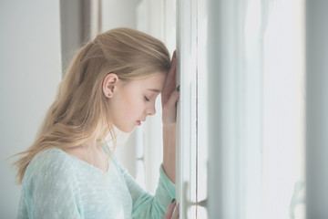 Pretty girl standing at window