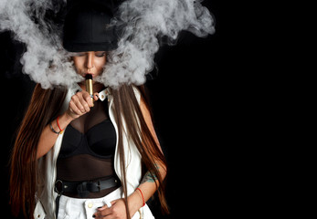 Young sexy woman is vaping. A cloud of vapor. Studio shooting.