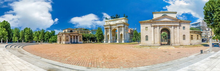 Fototapeta premium Ogromny, szeroki widok panoramy Arco della Pace, Porta Sempione, kolorowy słoneczny dzień w Mediolanie Włochy Podróż do celu zwiedzania Lato Błękitne niebo na zewnątrz Piękna architektura zabytków