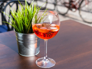 Spritz cocktail with ice on table in outdoor cafe