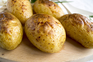 Spicy baked potatoes on wooden Board, closeup